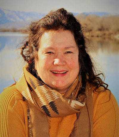 Portrait of Livia Millard standing outside with a lake in the background.