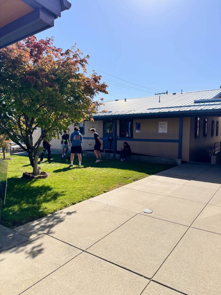 Students outside between Omak Administrative Services building and Hazel Burnett Hall