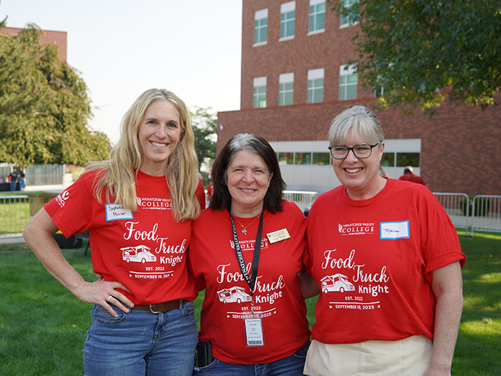 Three Food Truck Knight event volunteers in red shirts posing for photo.