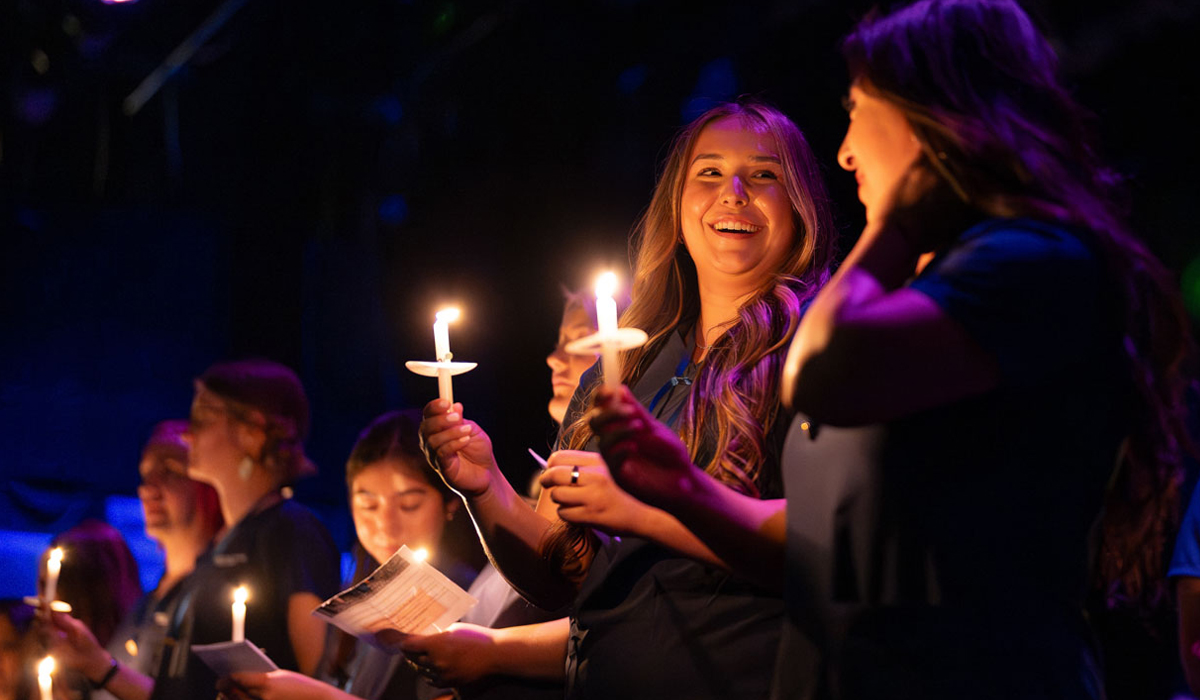 Two nursing graduates holding candles during the pinning ceremony.