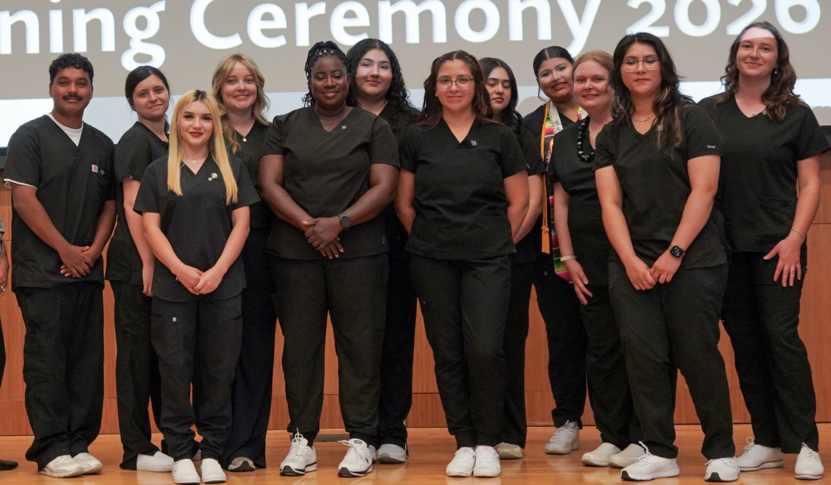 Medical Assistant graudates standing together on theatre stage.