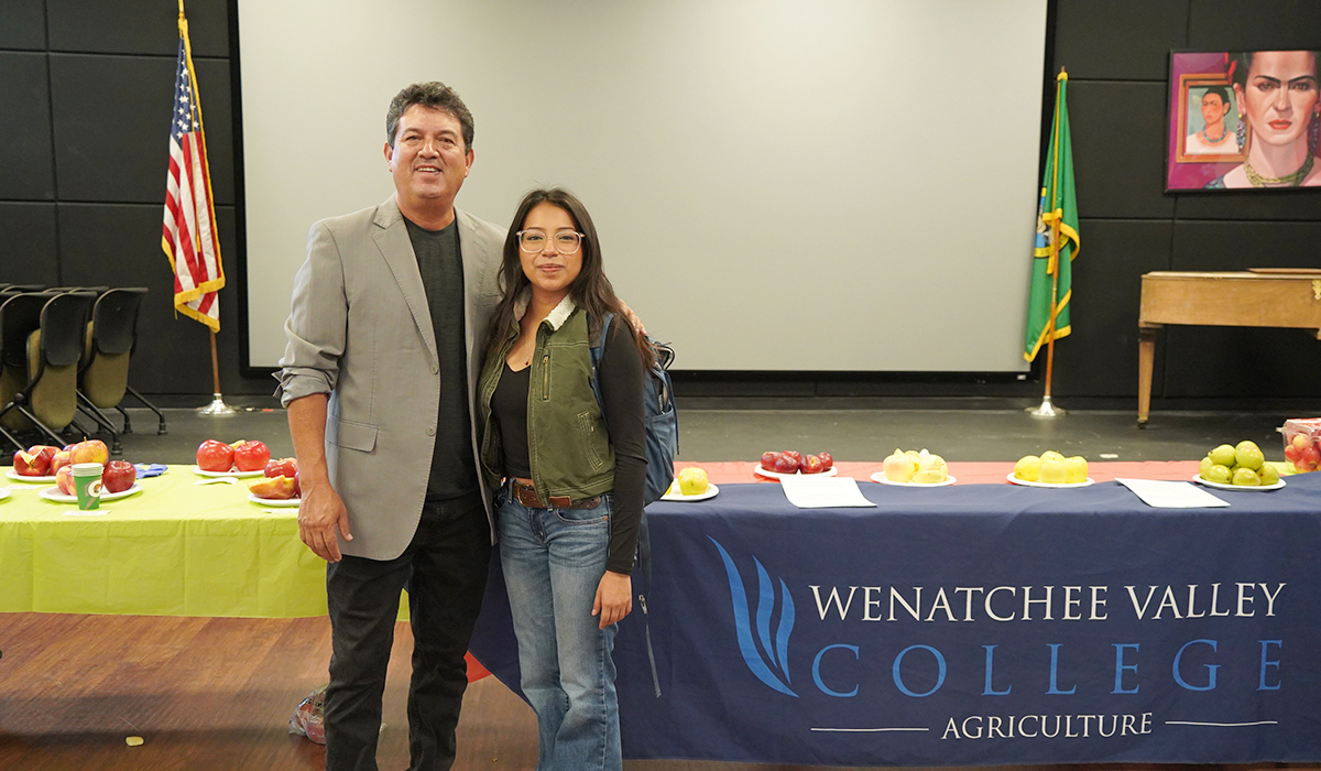 The WVC agriculture professor and a student stand in front of a table with sliced apples.