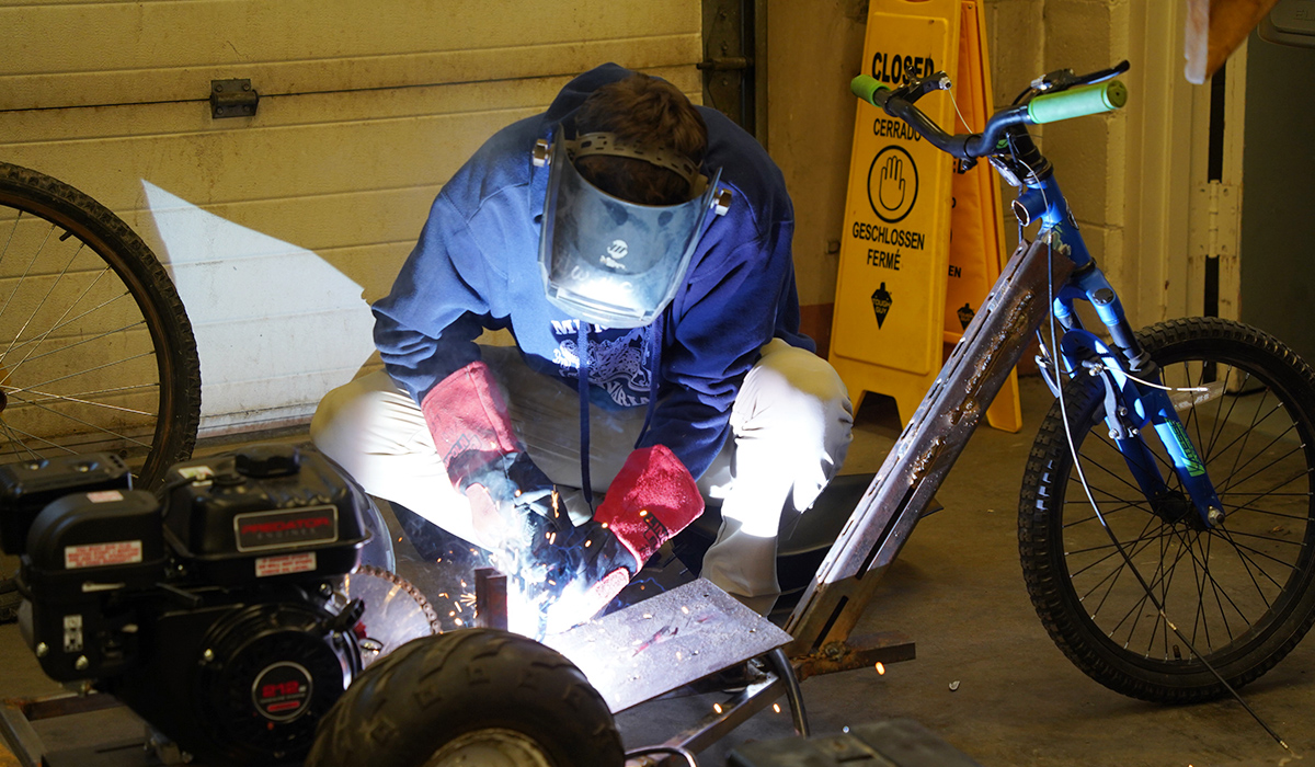 A student completes a weld on a motorized bike.