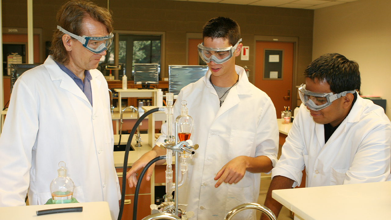 A WVC Chemistry professor watches two students conduct an experiment in the lab.
