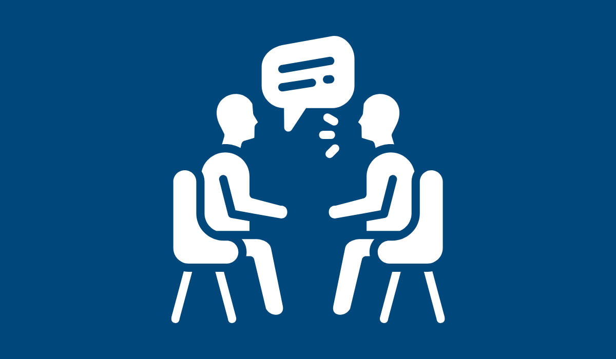 A white icon of two people speaking against a dark blue background.