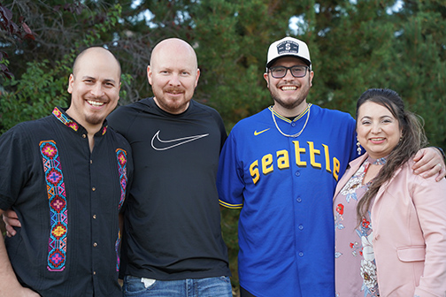 The four Mendoza siblings stand side-by-side against a backdrop of green trees.