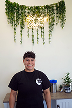 WVC alum Selina Longoria stands in front of a coffee table with a coffee sign