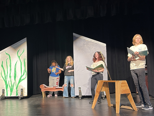 The cast of Arc: The Musical rehearses on the Wells Hall Theater stage.
