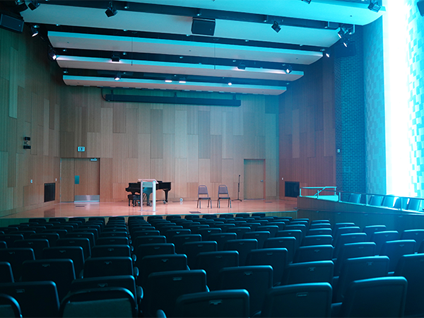 The Grove Recital Hall in the WVC Music and Art Center cast in a blue light from the recital hall's side lights.