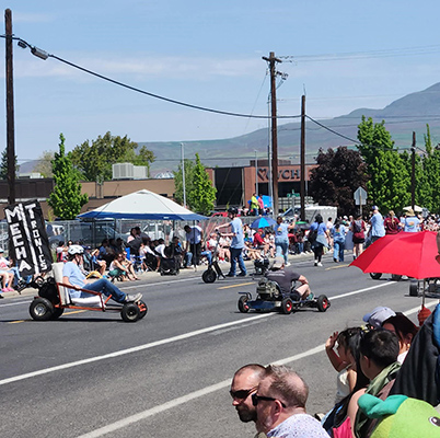 The Mechatronics Club members drive their karts along the road during the Apple Blossom Parade.