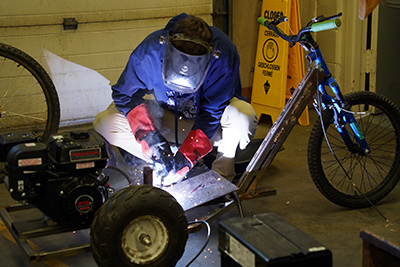 A WVC student completes a weld on a go kart.