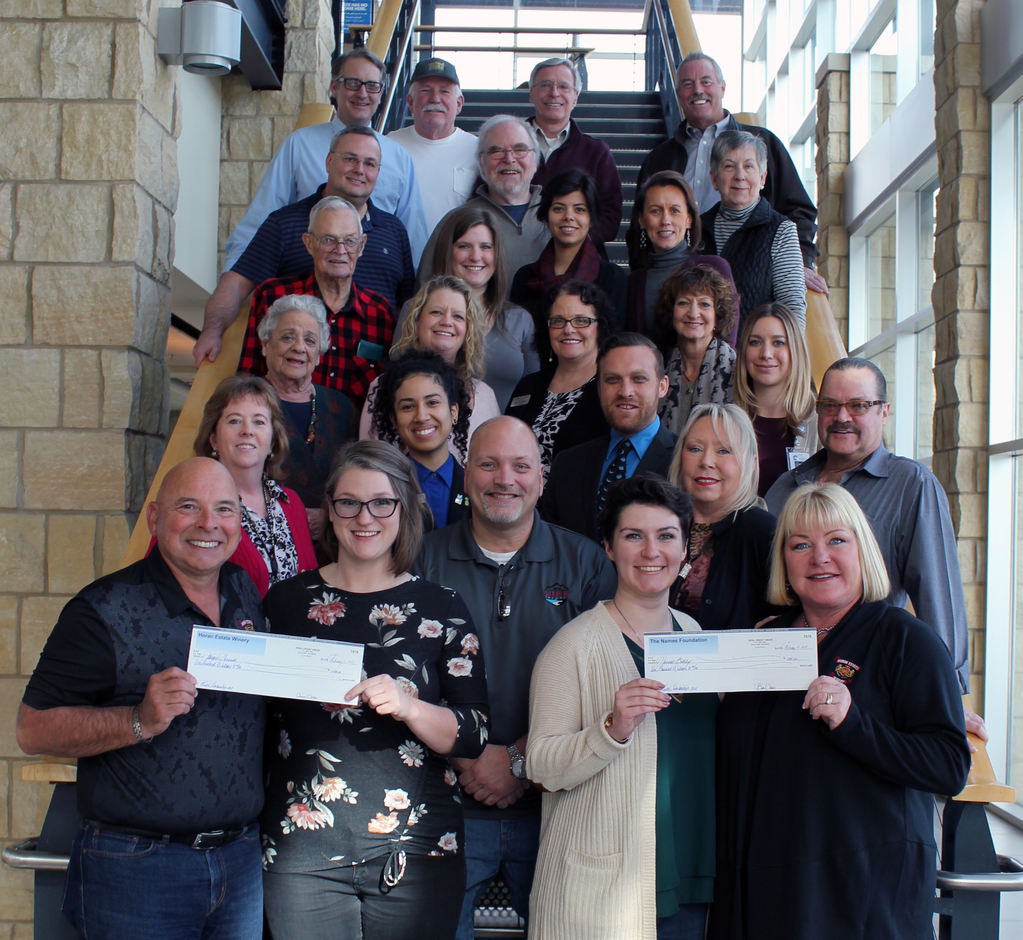 Students receive RLS Productions scholarship with many people present.